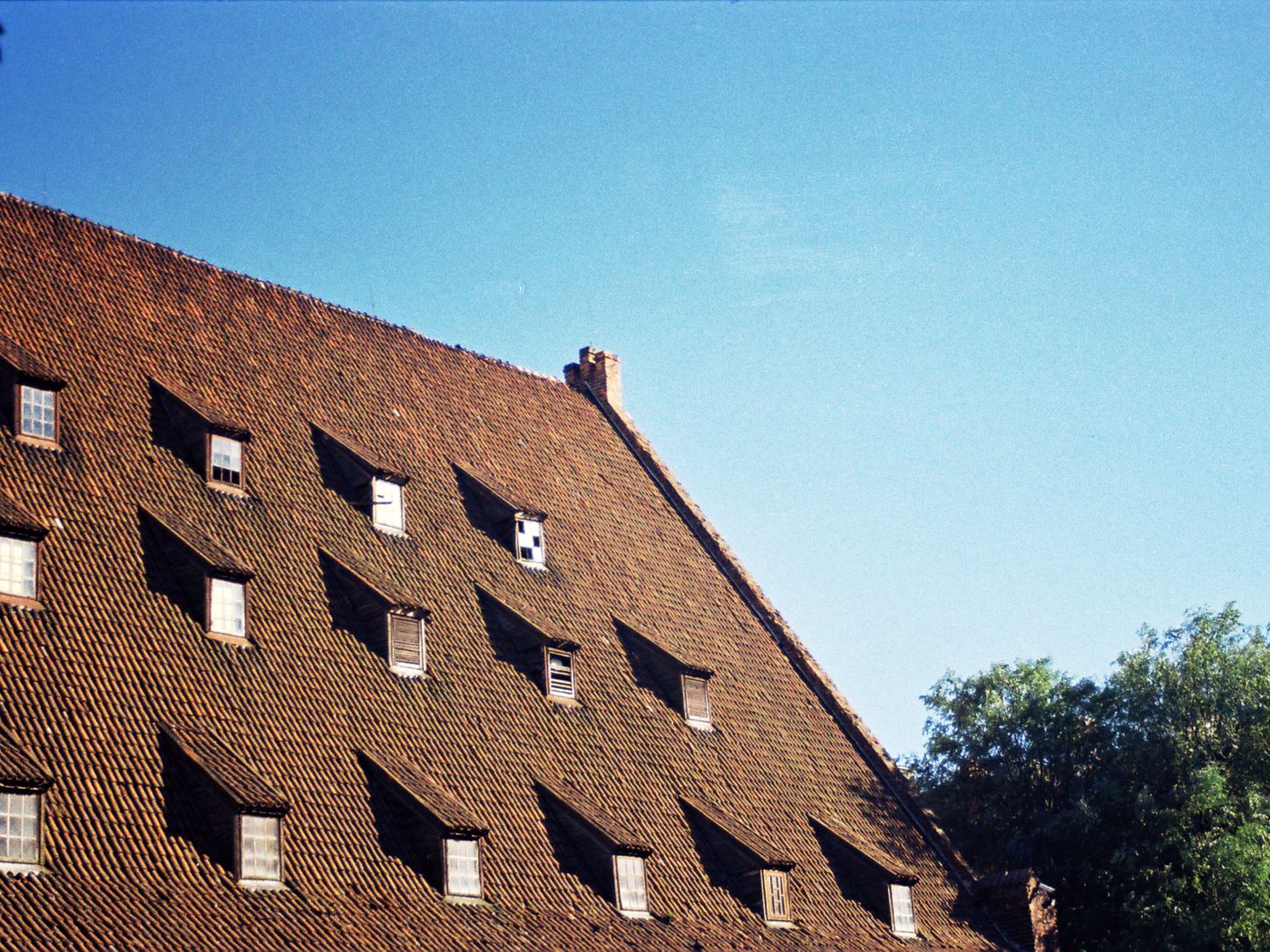 Grande toiture en tuiles anciennes rythmée par des lucarnes